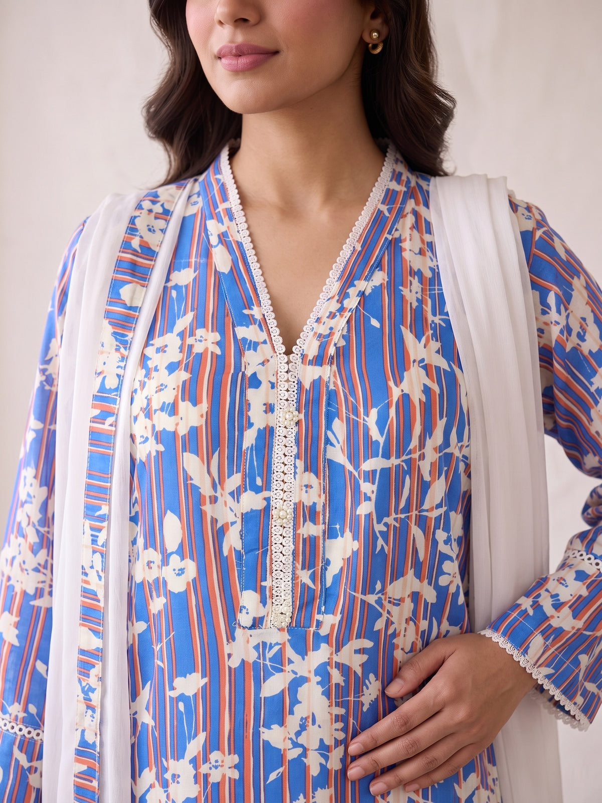 V-neck lace and pearl placket close-up on cobalt blue linen shirt