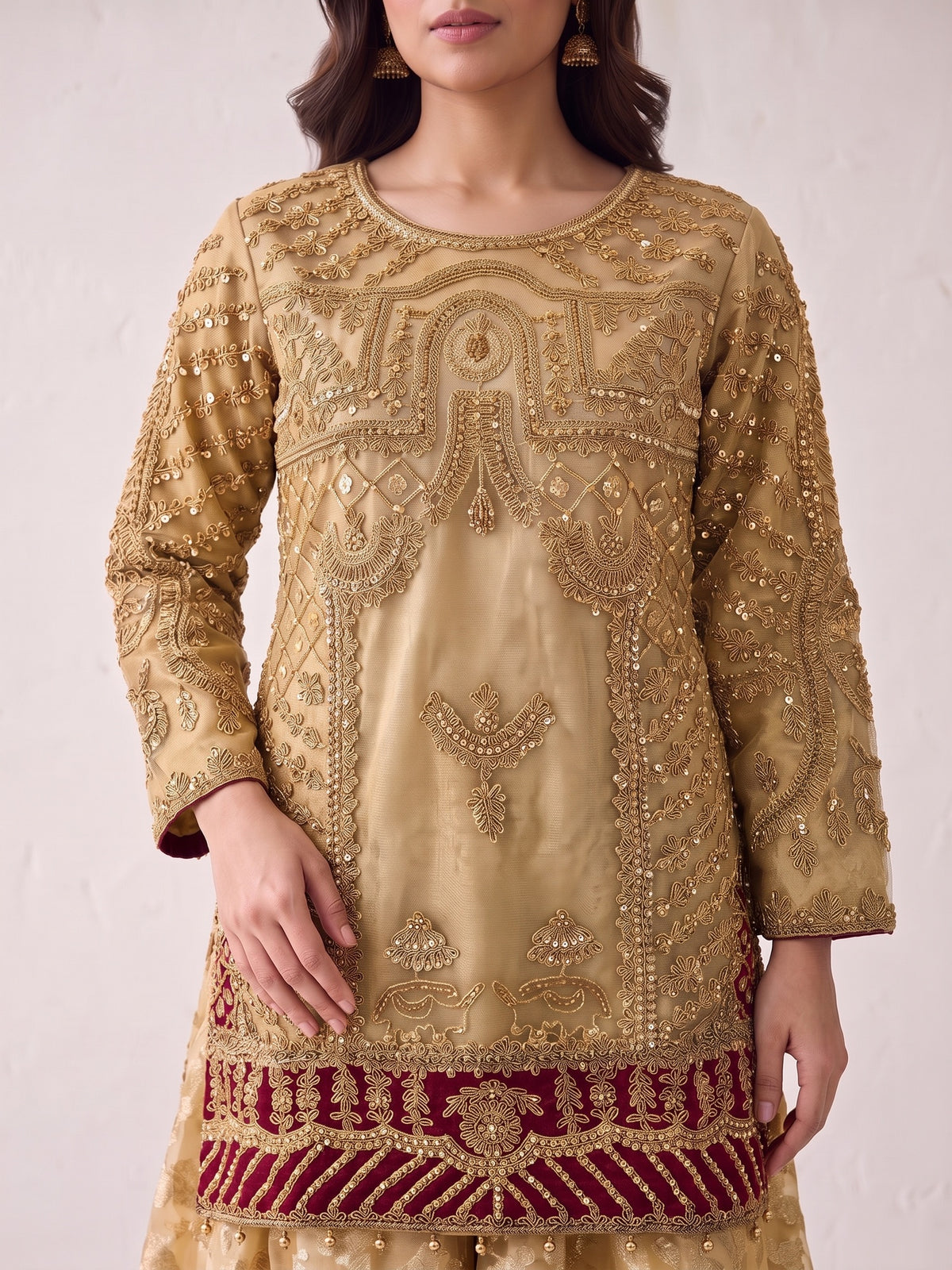 Heavy tilla embroidery close-up on gold net shirt with maroon hem band