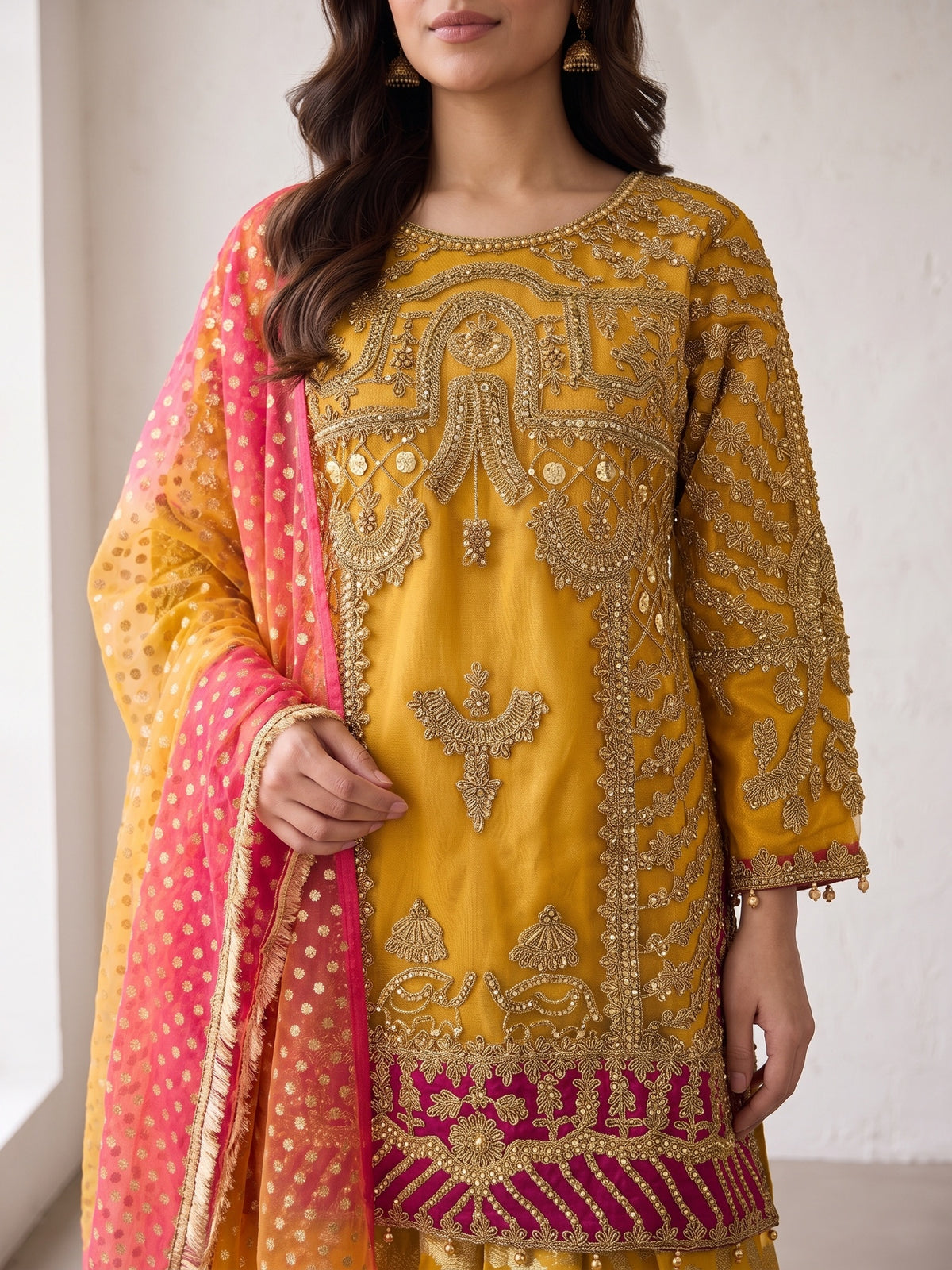Heavy tilla embroidery close-up on mustard net shirt with magenta hem band